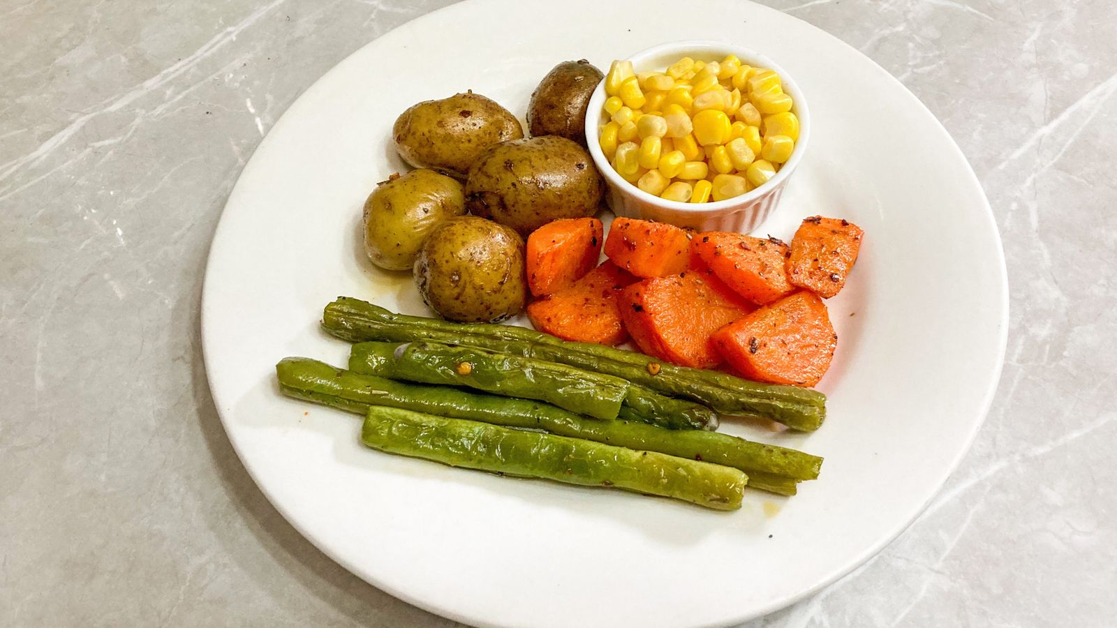 Mixed roasted vegetables and meat cooked together in an air fryer basket