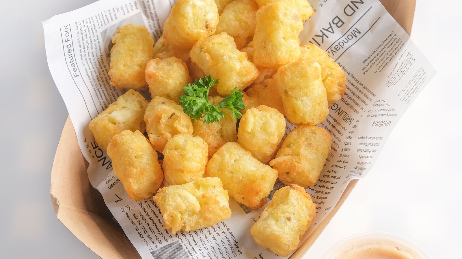 Crispy golden tater tots served as a side dish alongside air-fried meat
