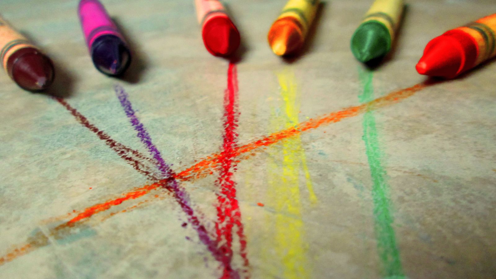 Colorful crayon marks left on flooring near a child's drawing area