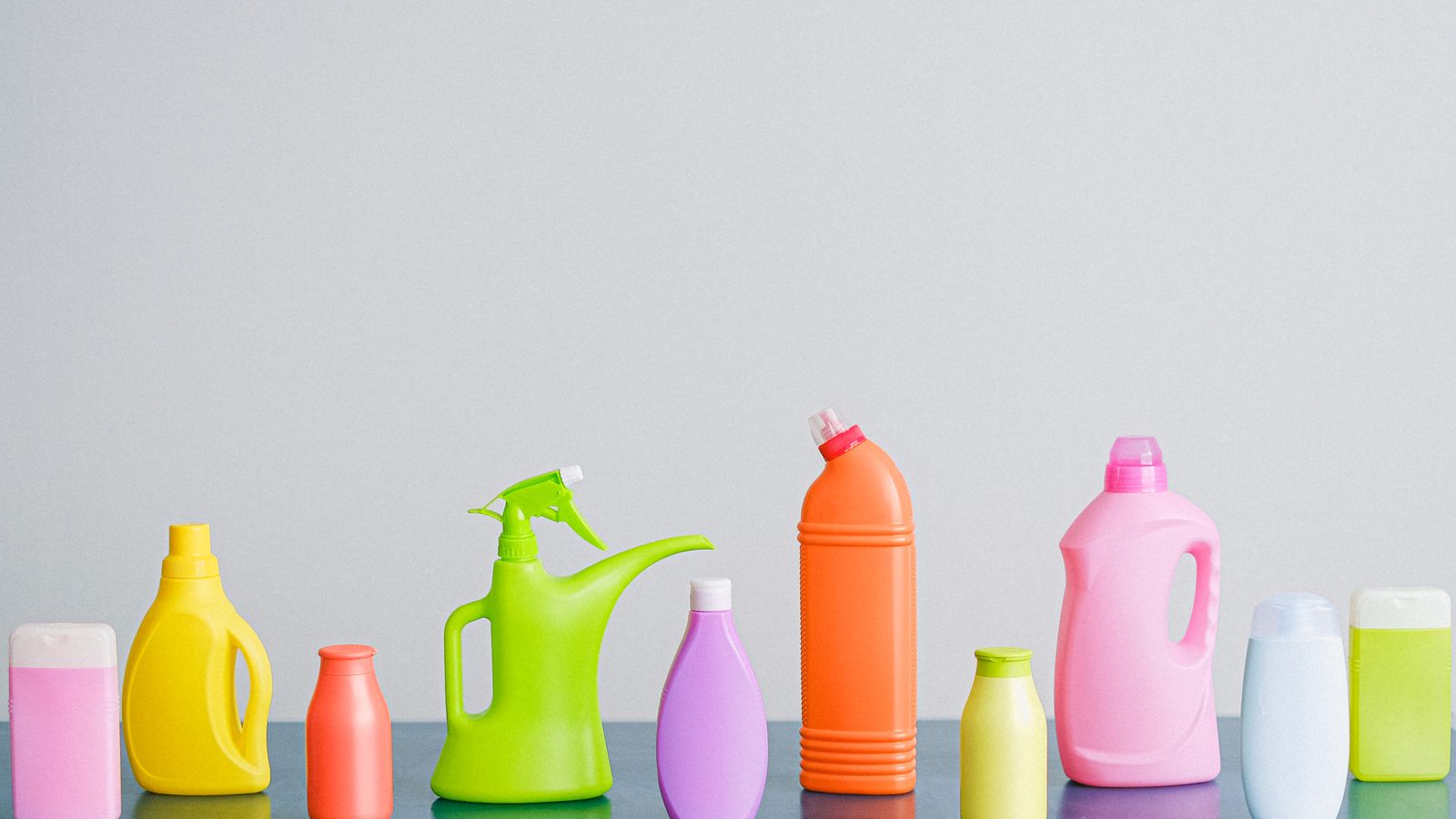 Assorted carpet cleaning supplies including spray bottles and detergent arranged for a starter kit