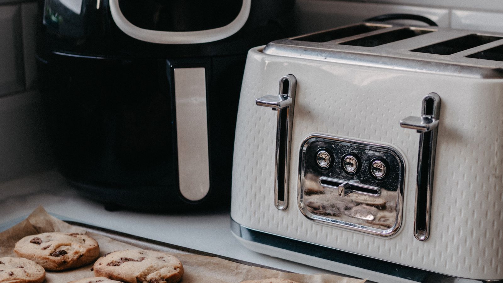 Compact air fryer oven with a front door sitting on a modern kitchen countertop