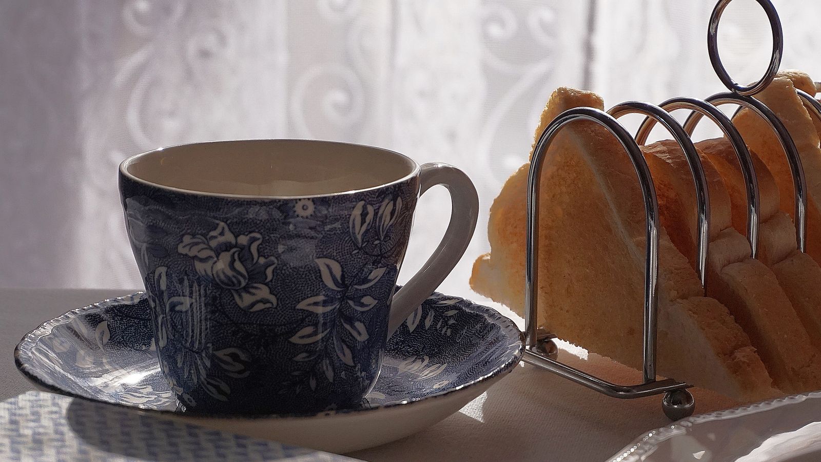 Metal toast rack sitting on a kitchen counter next to sliced bread