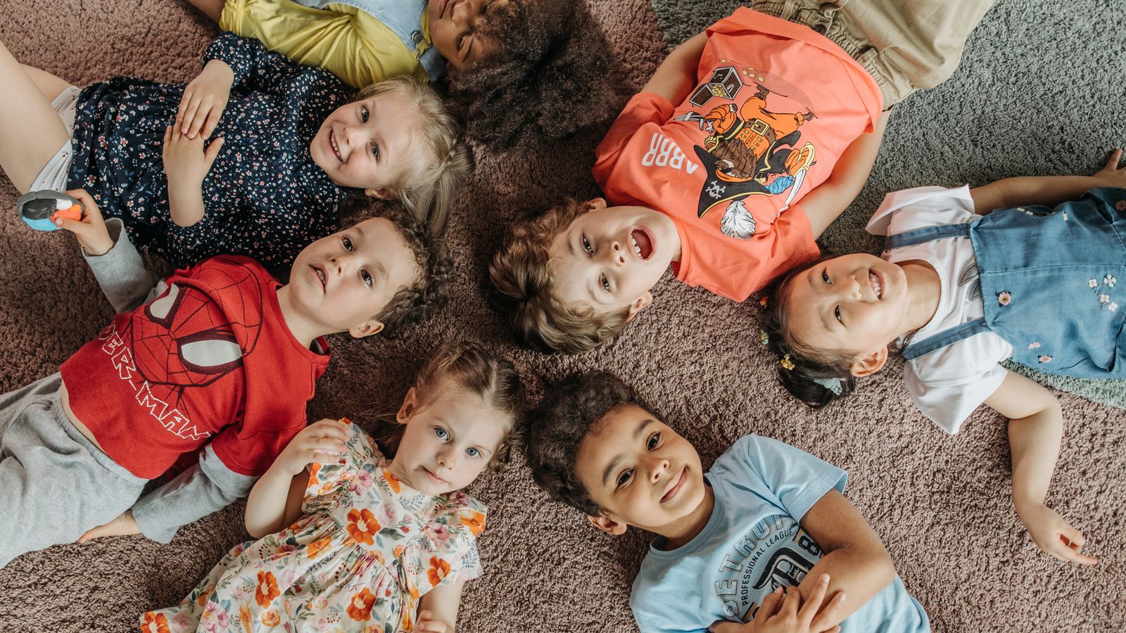 Children playing on a clean carpet in a daycare-style playroom