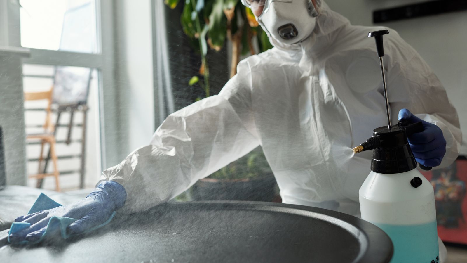Technician applying disinfectant spray as part of a commercial cleaning fleet routine