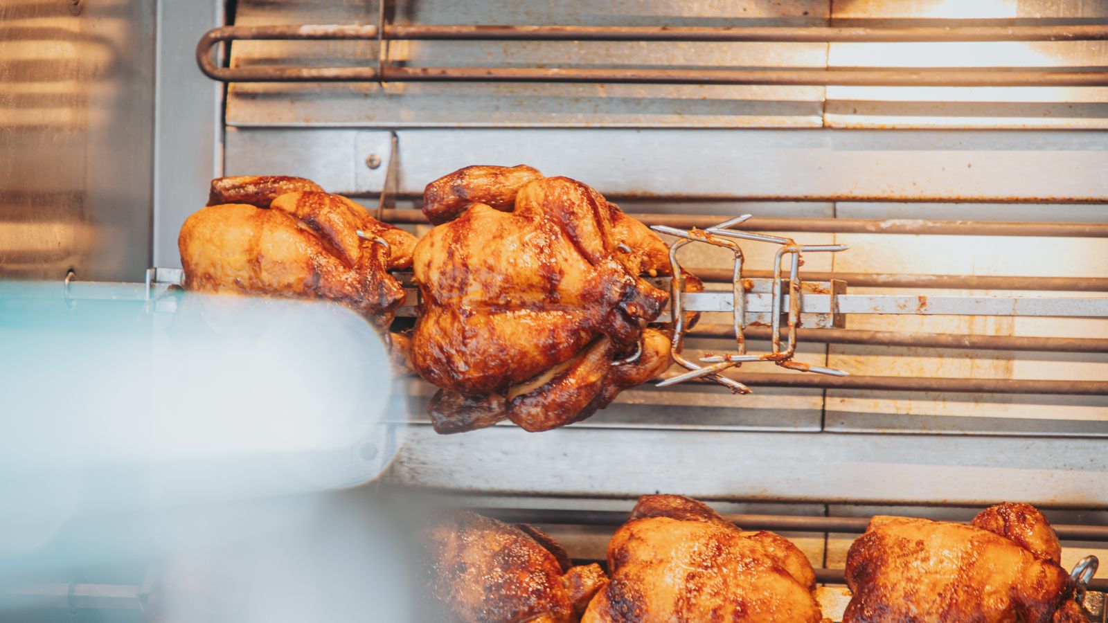 Golden rotisserie chicken cooked on a rotating spit