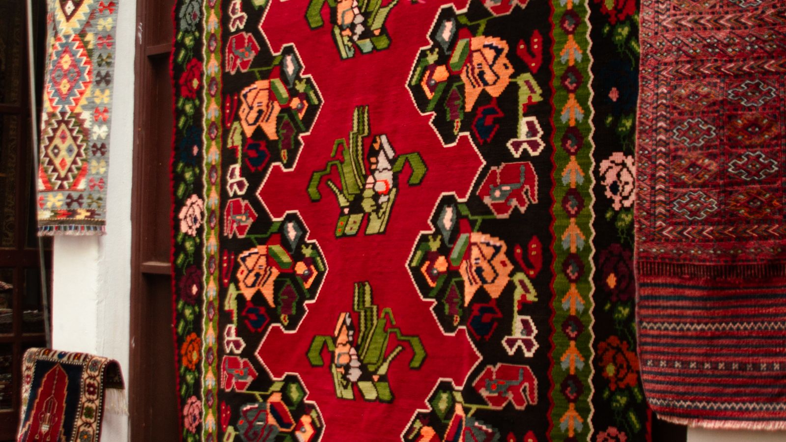 Rolled area rug on a hardwood floor next to a rug pad before installation
