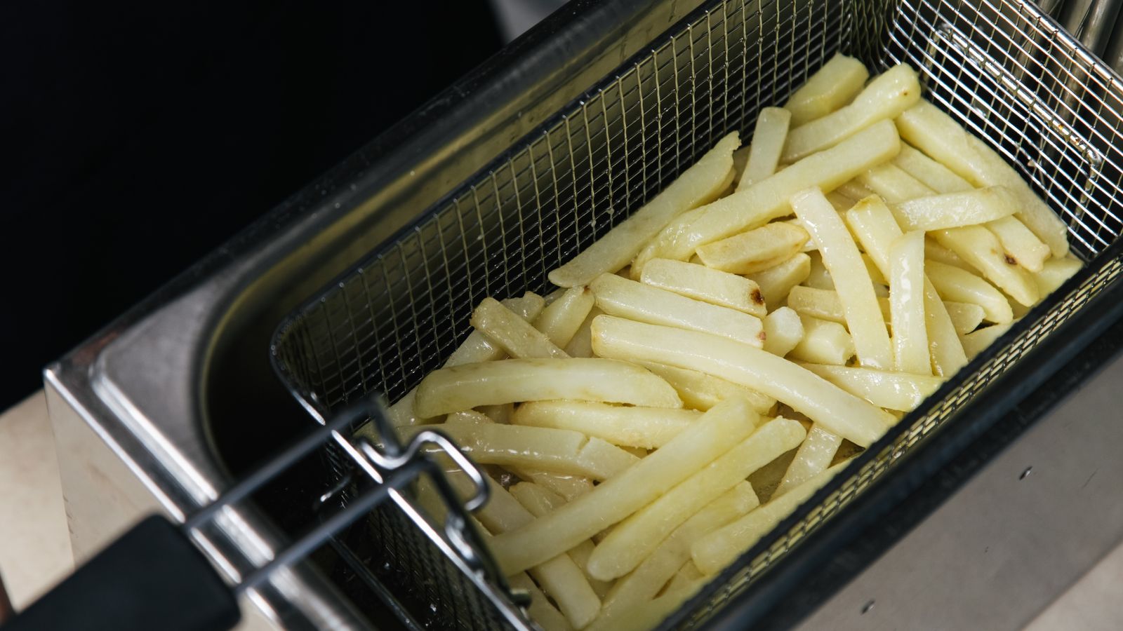 Clean empty air fryer basket with mesh holes after washing
