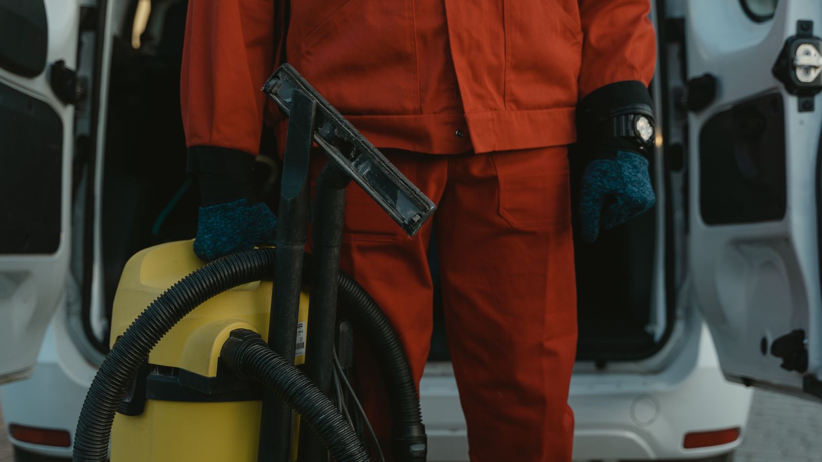 Professional cleaning technician using commercial vacuum equipment in an office building