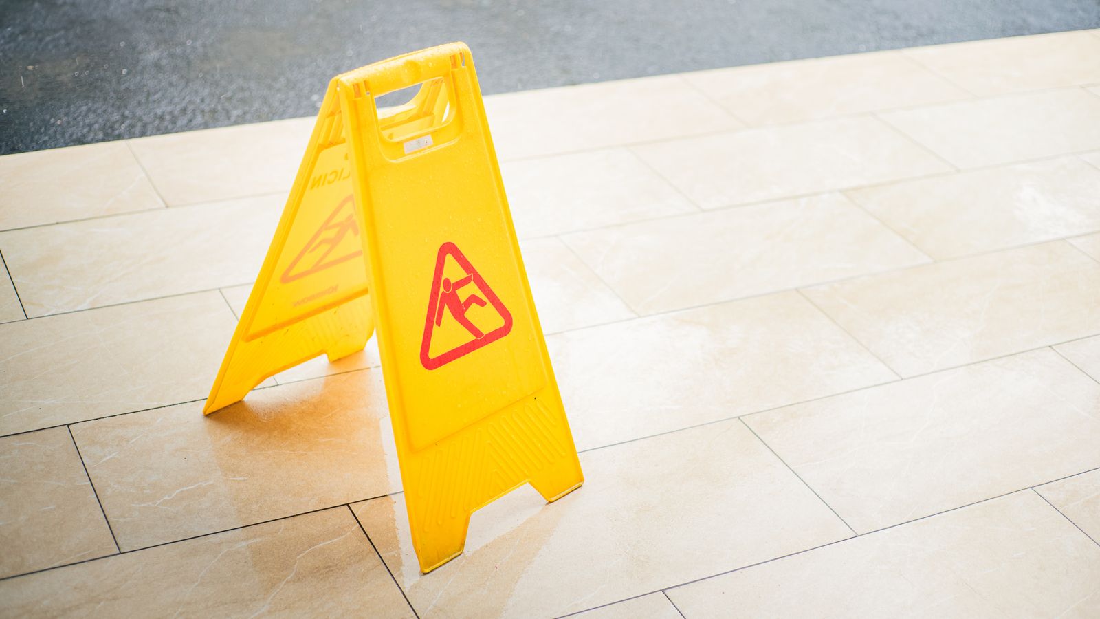 Yellow wet floor caution sign placed on a commercial building floor