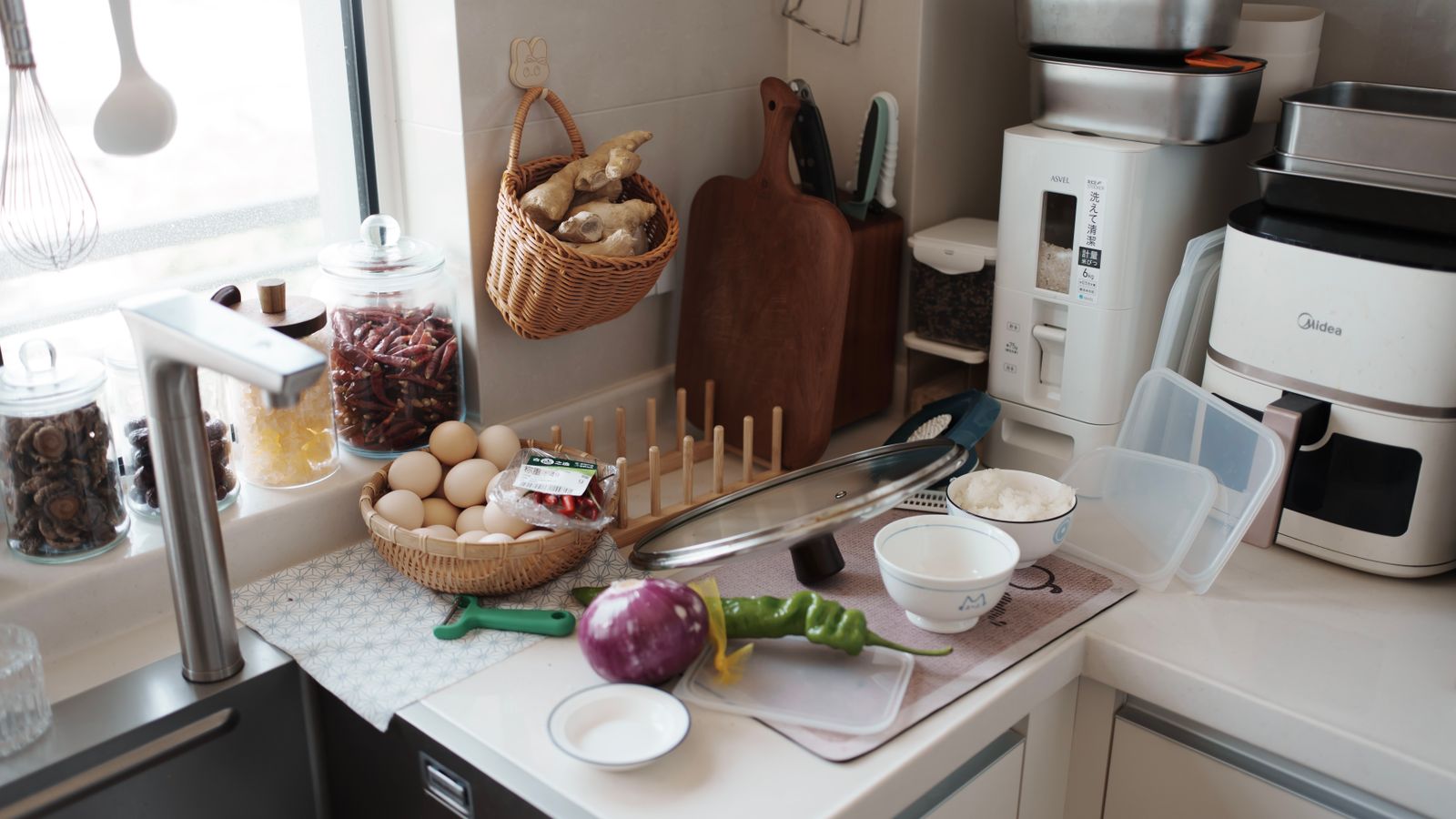 Kitchen counter with air fryer accessories and ingredients arranged for cooking