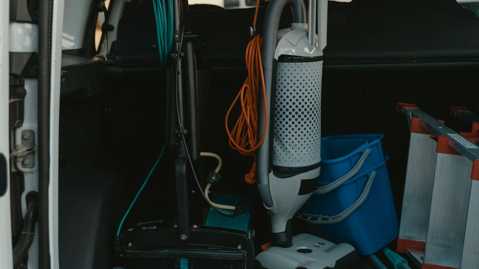 Commercial cleaning equipment including hoses and machines staged near a service vehicle