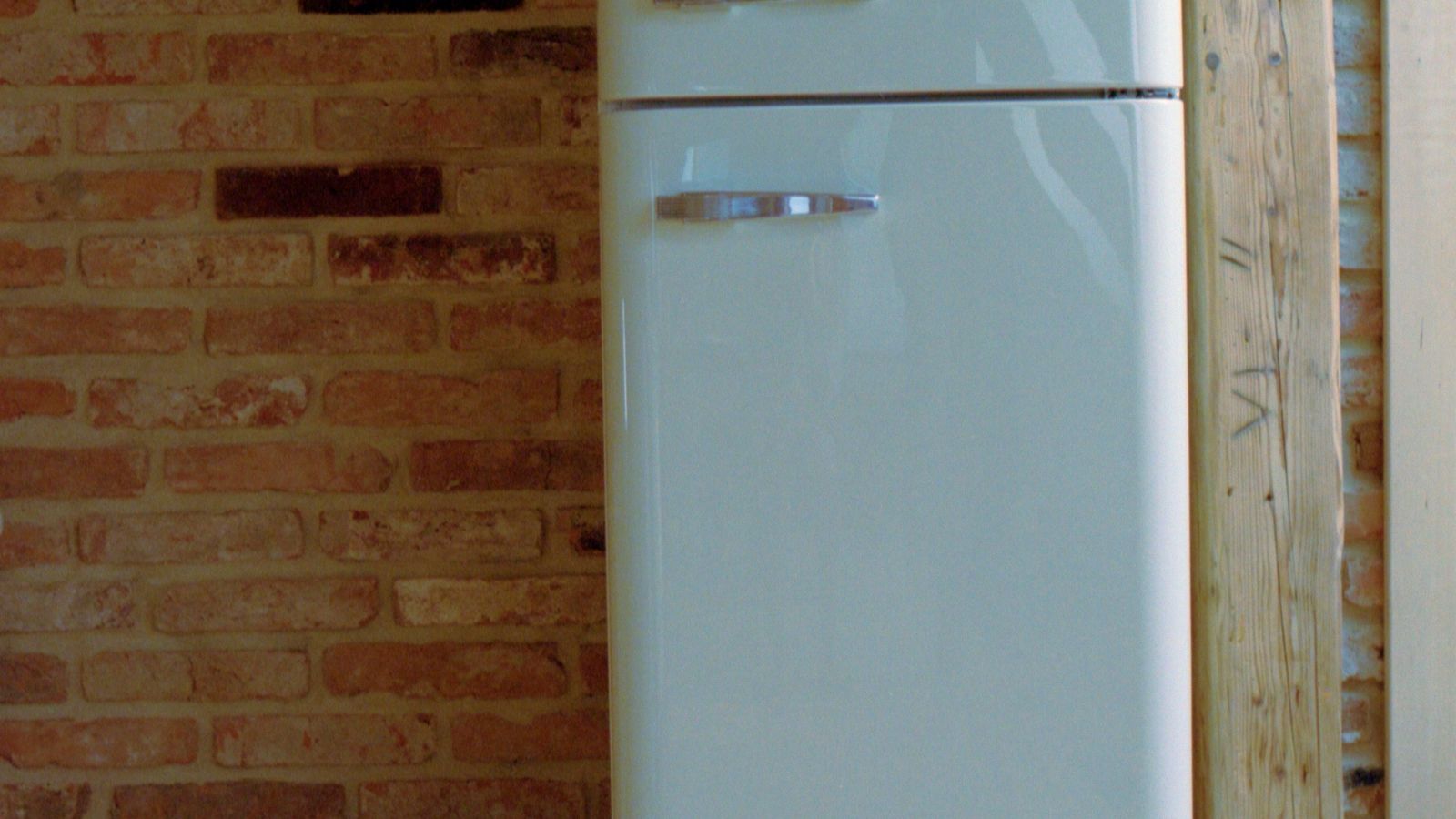 Bright kitchen with a refrigerator near a window showing where magnets are commonly placed