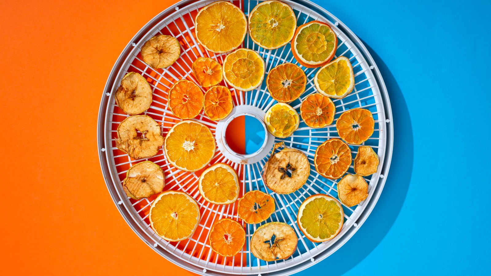 Dried fruit slices arranged on a dehydrator rack after an air fryer dehydrating cycle
