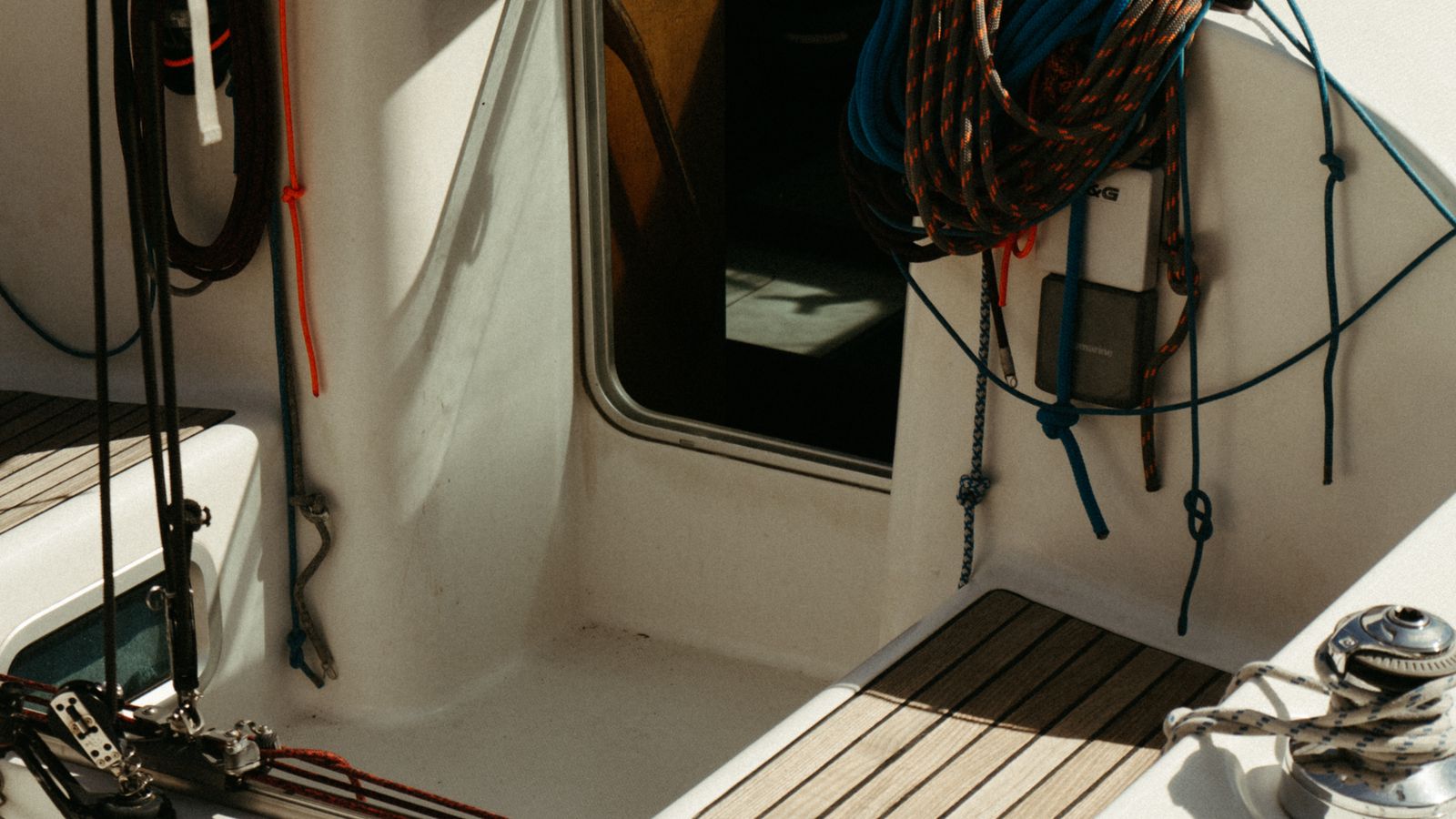 Marine carpet cleaning equipment stored on a boat deck near coiled rope