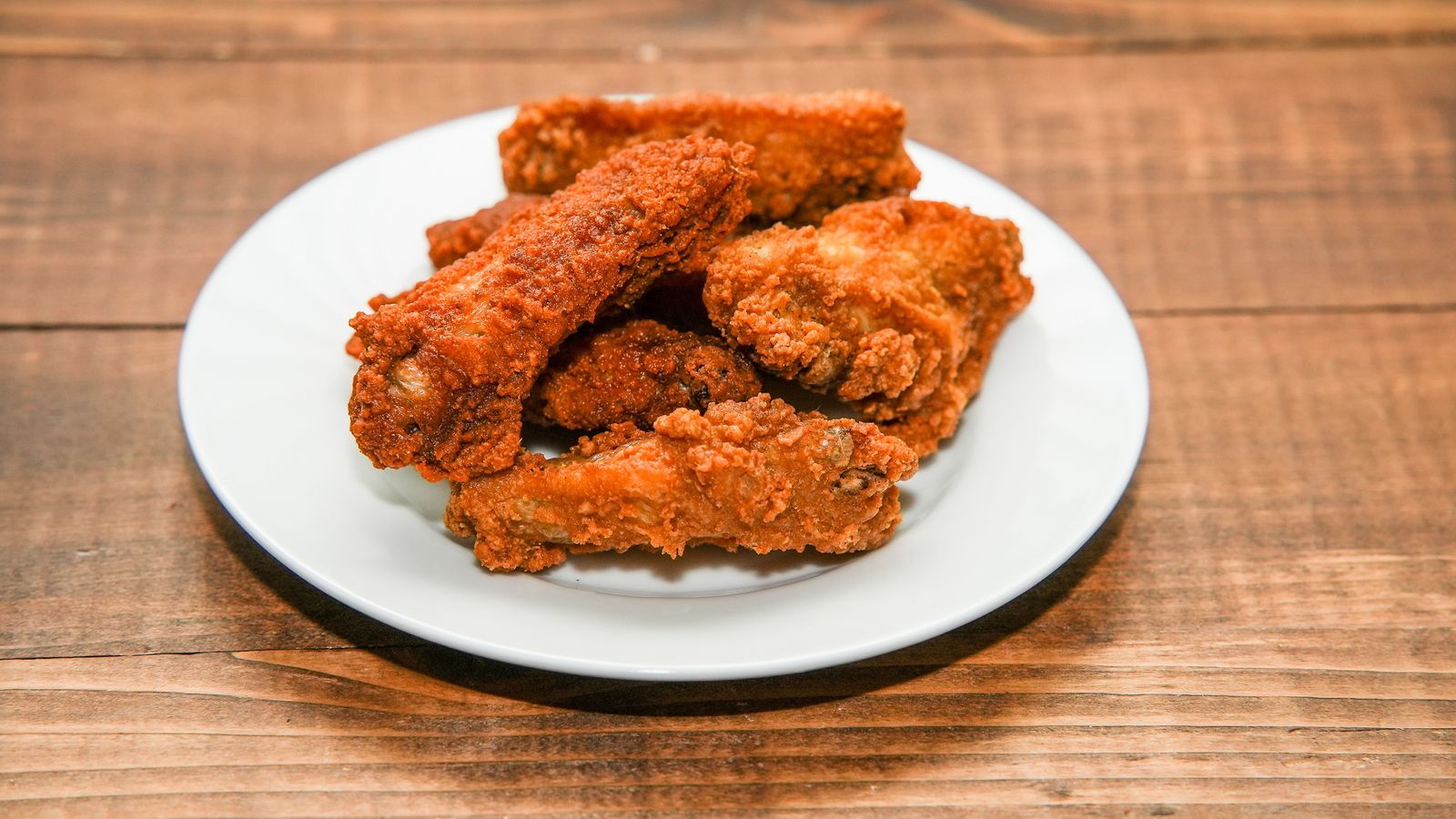 Batch of crispy golden chicken wings served on a plate for a holiday gathering appetizer
