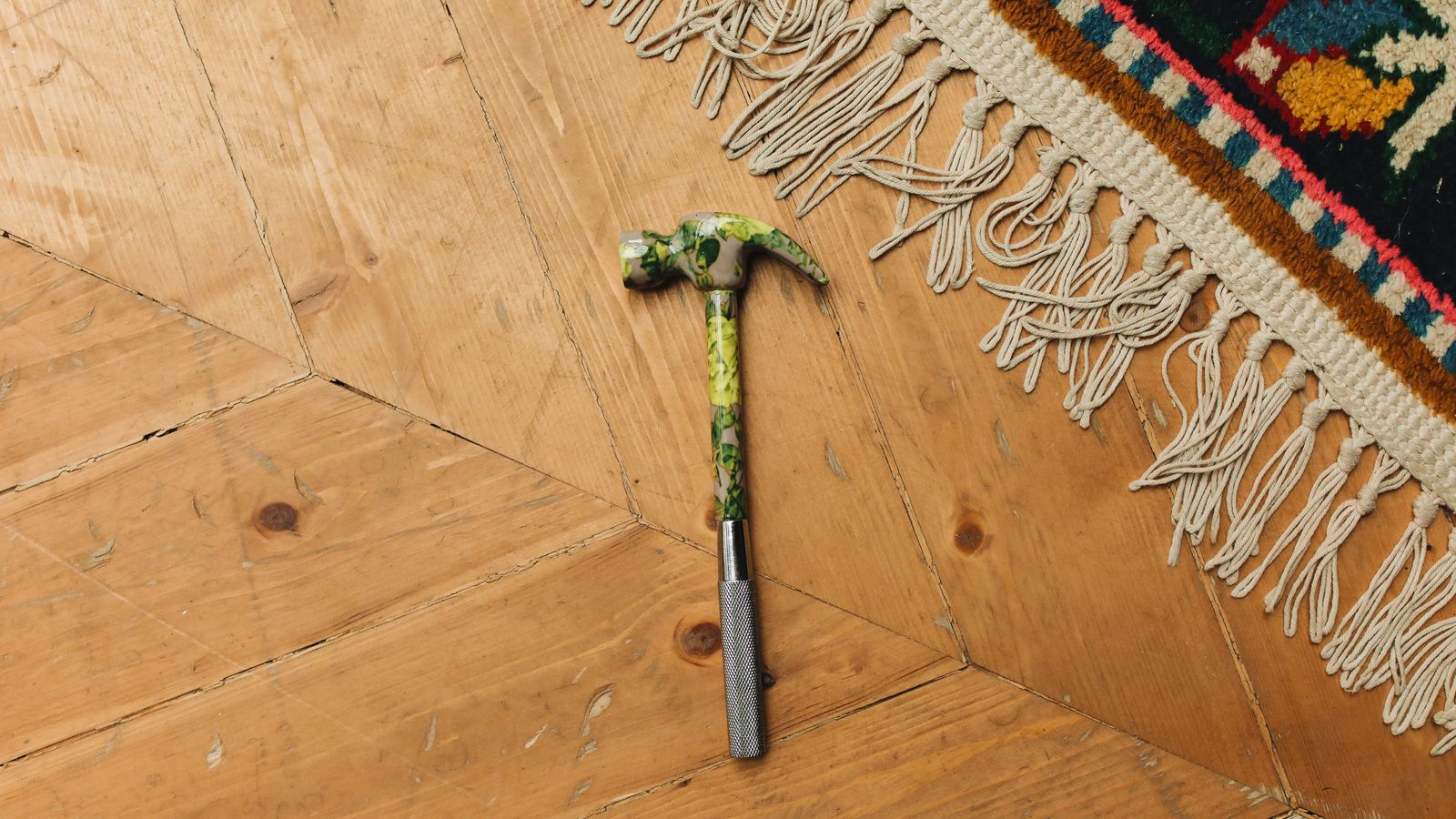 A rolled carpet being prepared and secured before restretching on a wooden floor