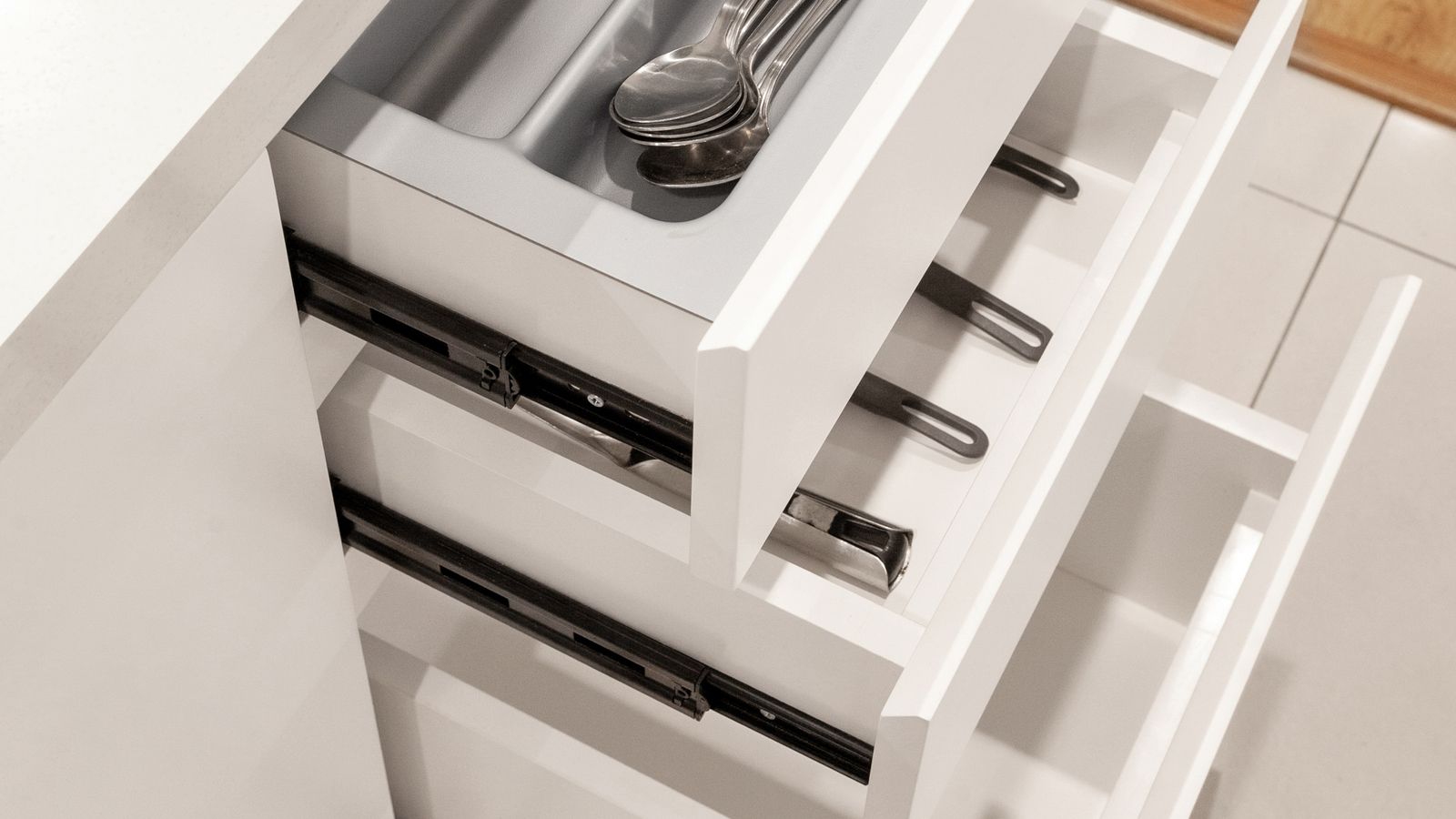 Open kitchen drawer with air fryer accessories neatly arranged in a divided organizer