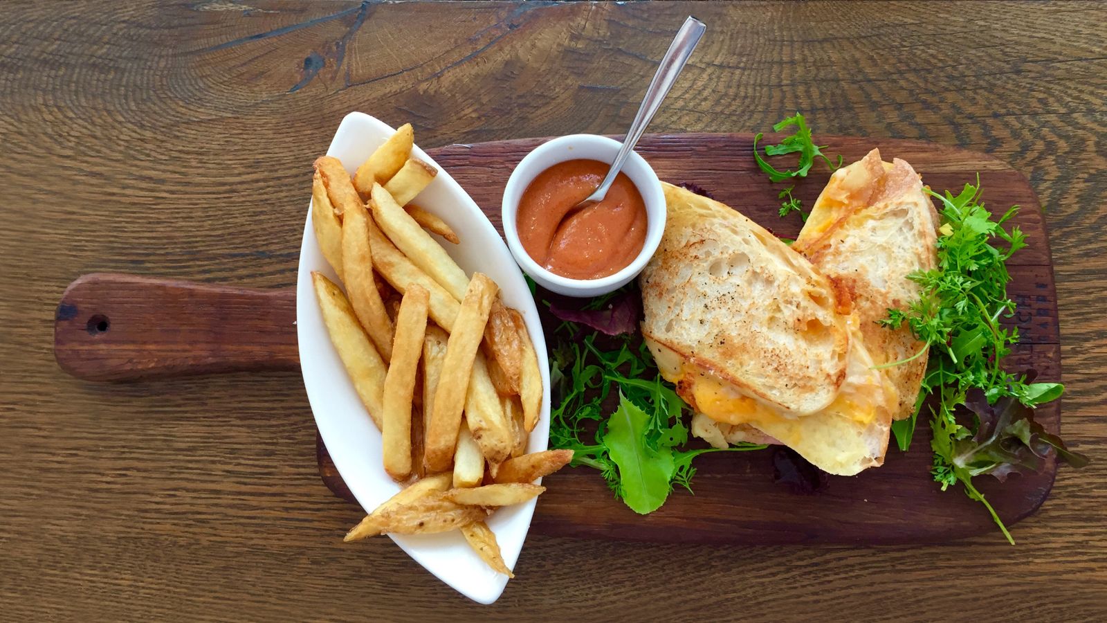 Golden grilled cheese sandwich cut in half on a plate