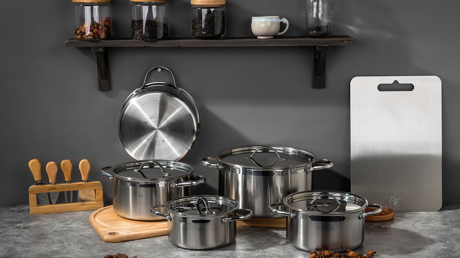 Stainless steel cookware set with pots and pans arranged on a kitchen counter