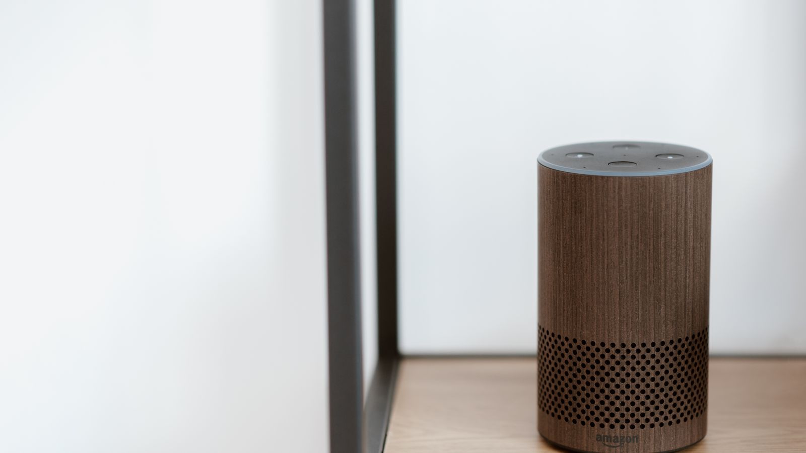 Compact smart speaker sitting on a kitchen counter next to cooking appliances