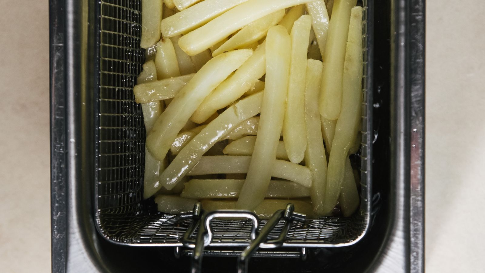 Small compact air fryer with digital display on a narrow kitchen counter