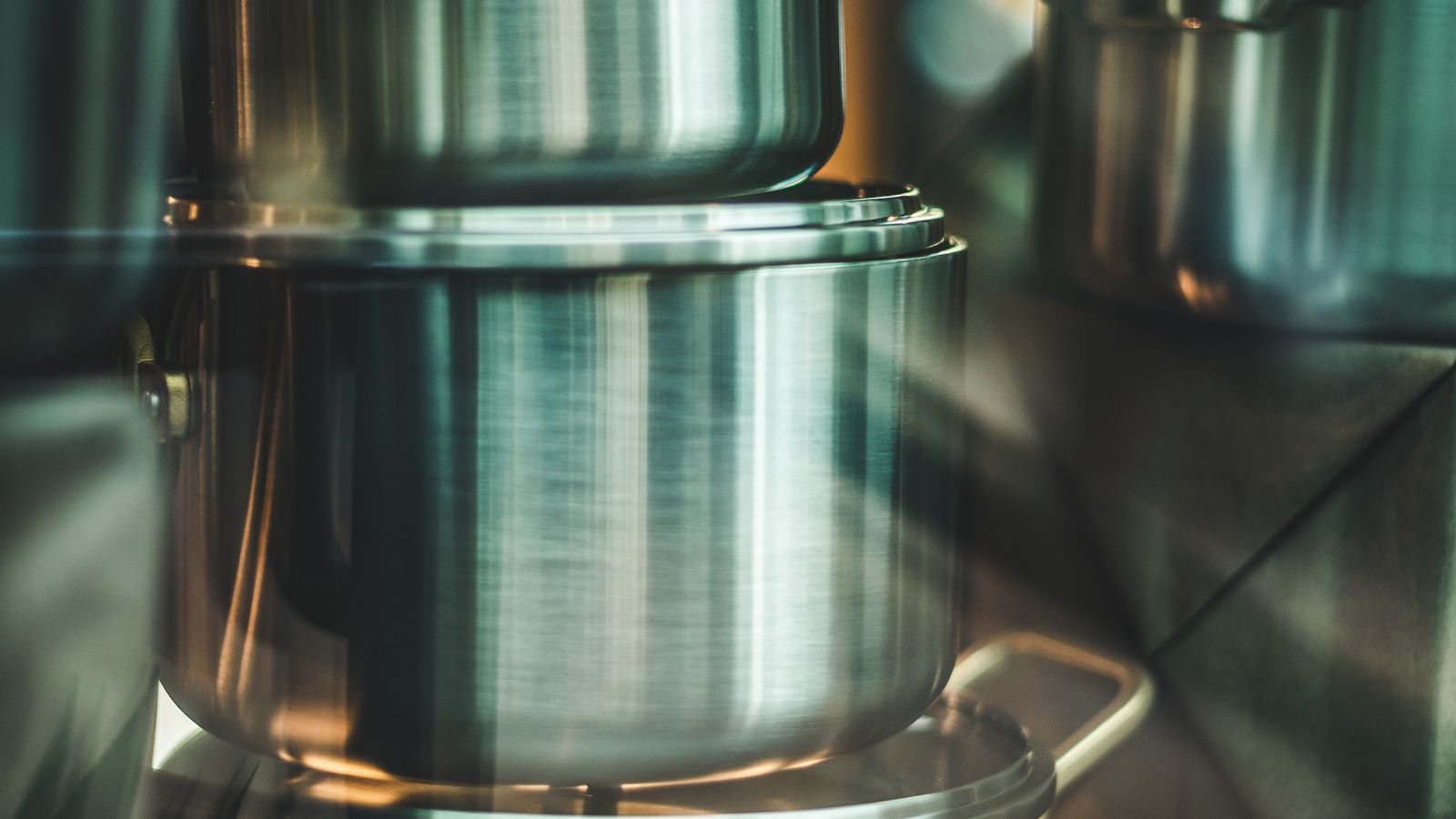 Stacked stainless steel pots and pans arranged to save cabinet space