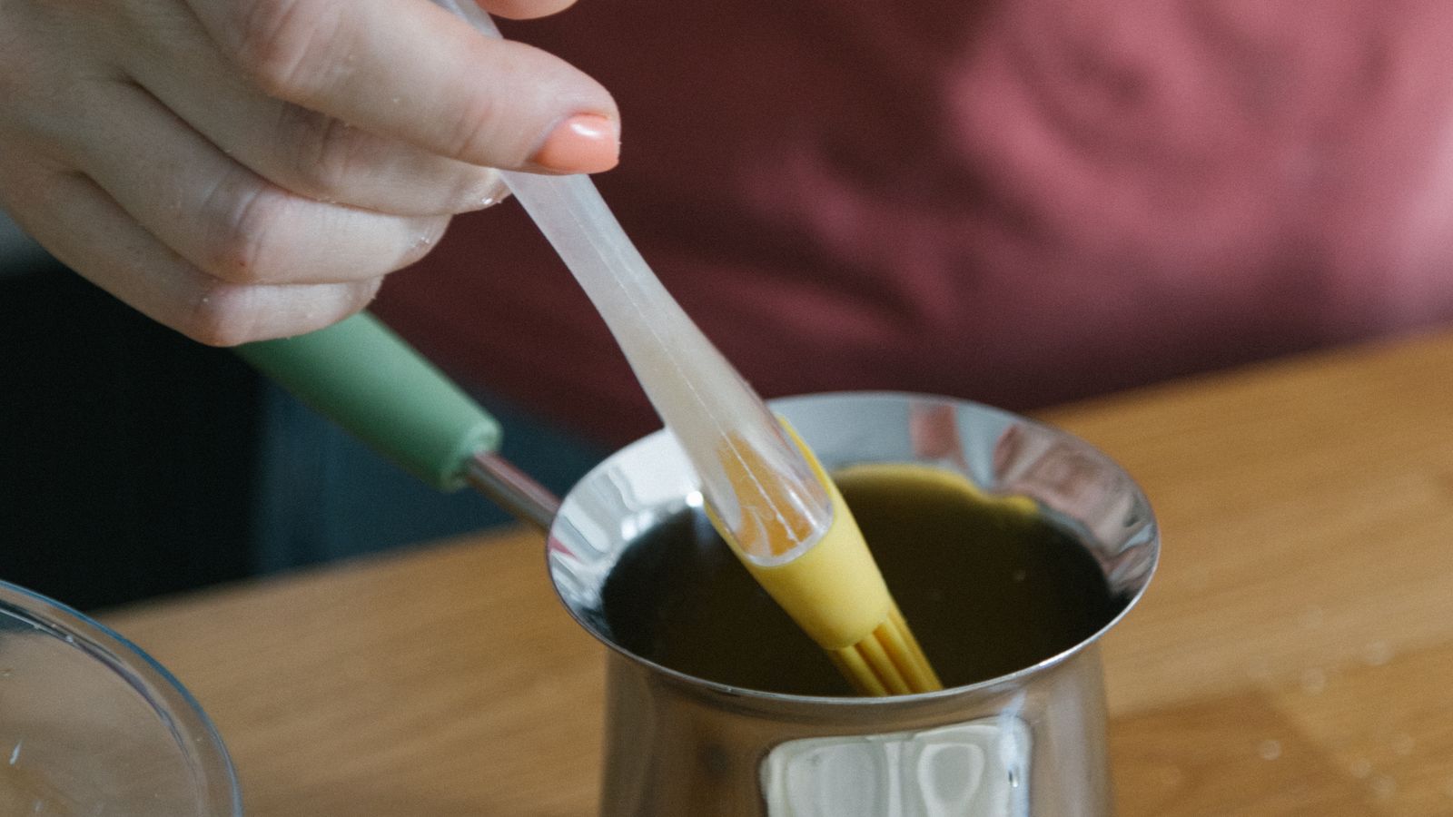 Hand using a silicone oil brush to coat food before air frying