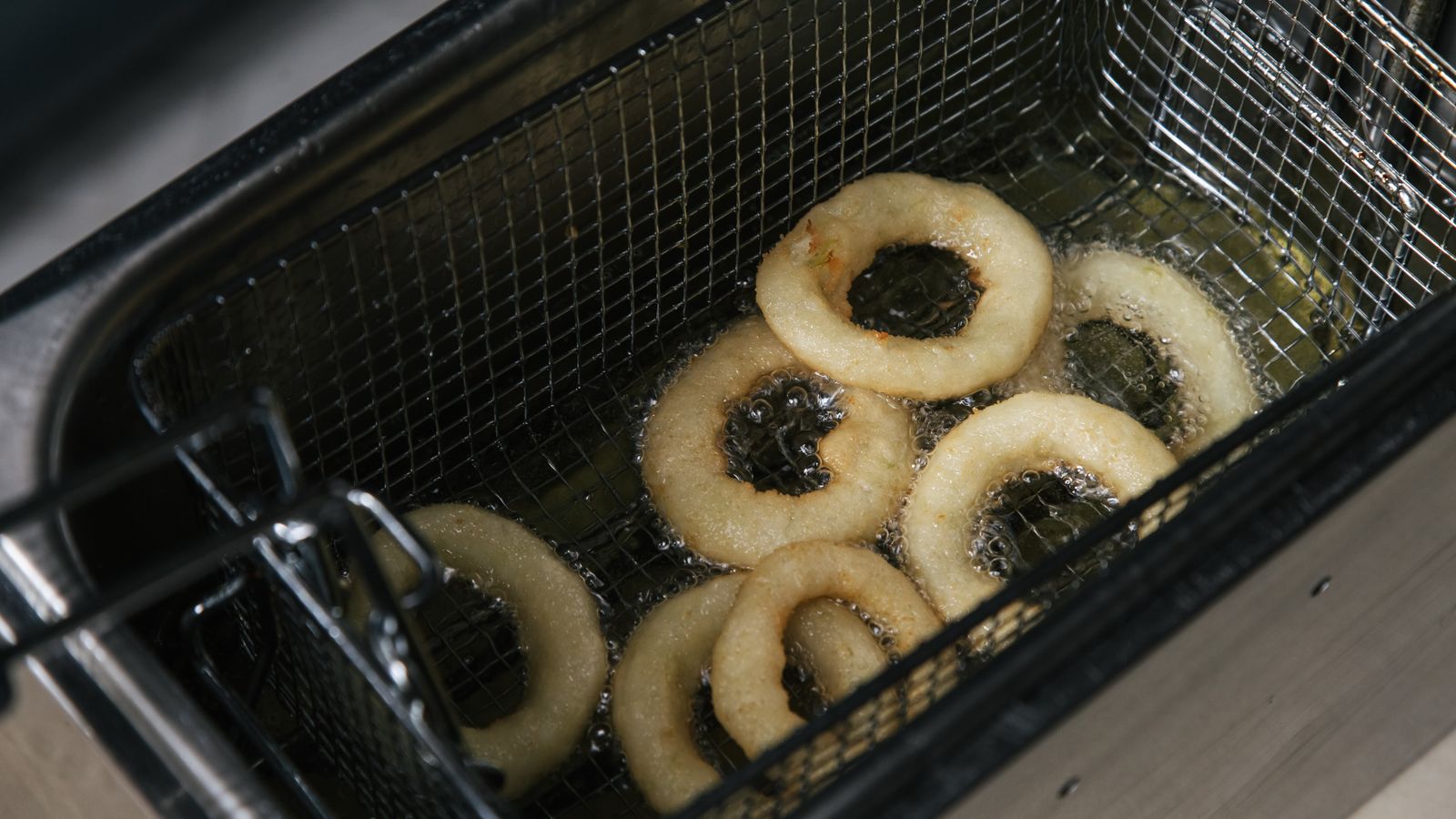 Basket divider separating two different foods for even air frying