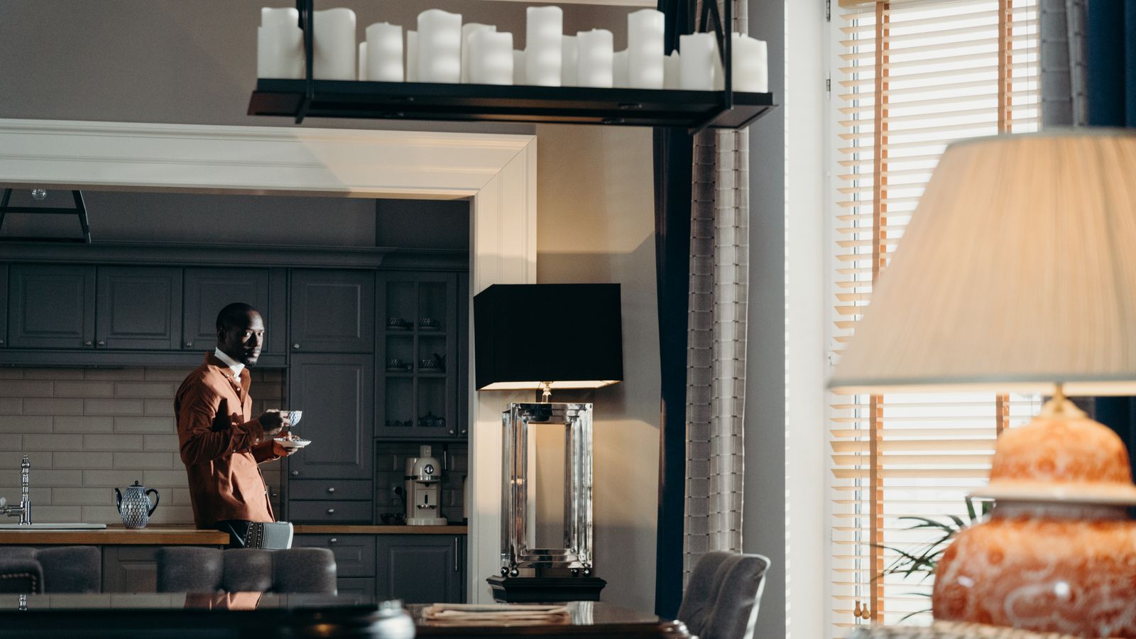 A bachelor preparing a simple meal in a compact apartment kitchen with an air fryer on the counter