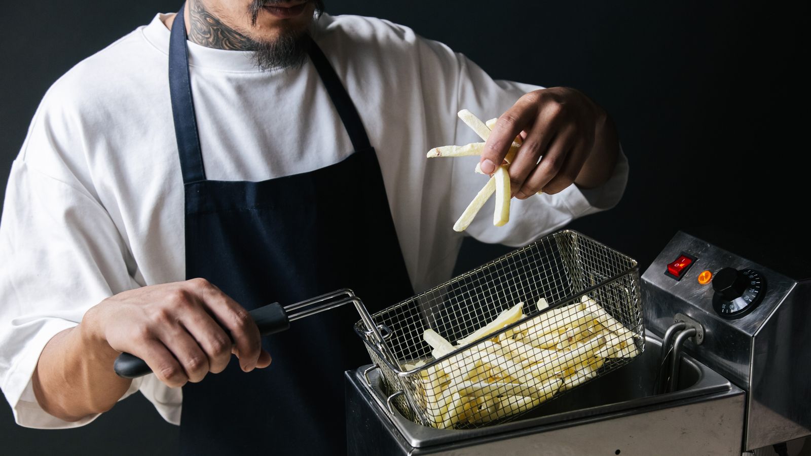 Perforated air fryer crisper tray next to a metal oven rack on a kitchen counter