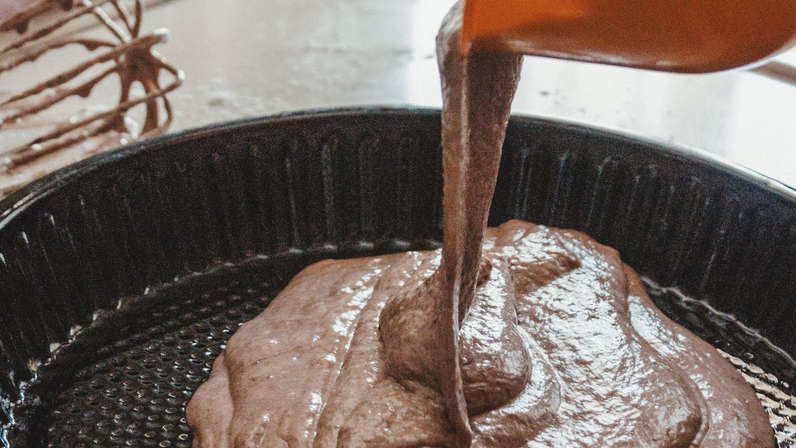 A round air fryer cake pan resting on a kitchen counter after cleaning