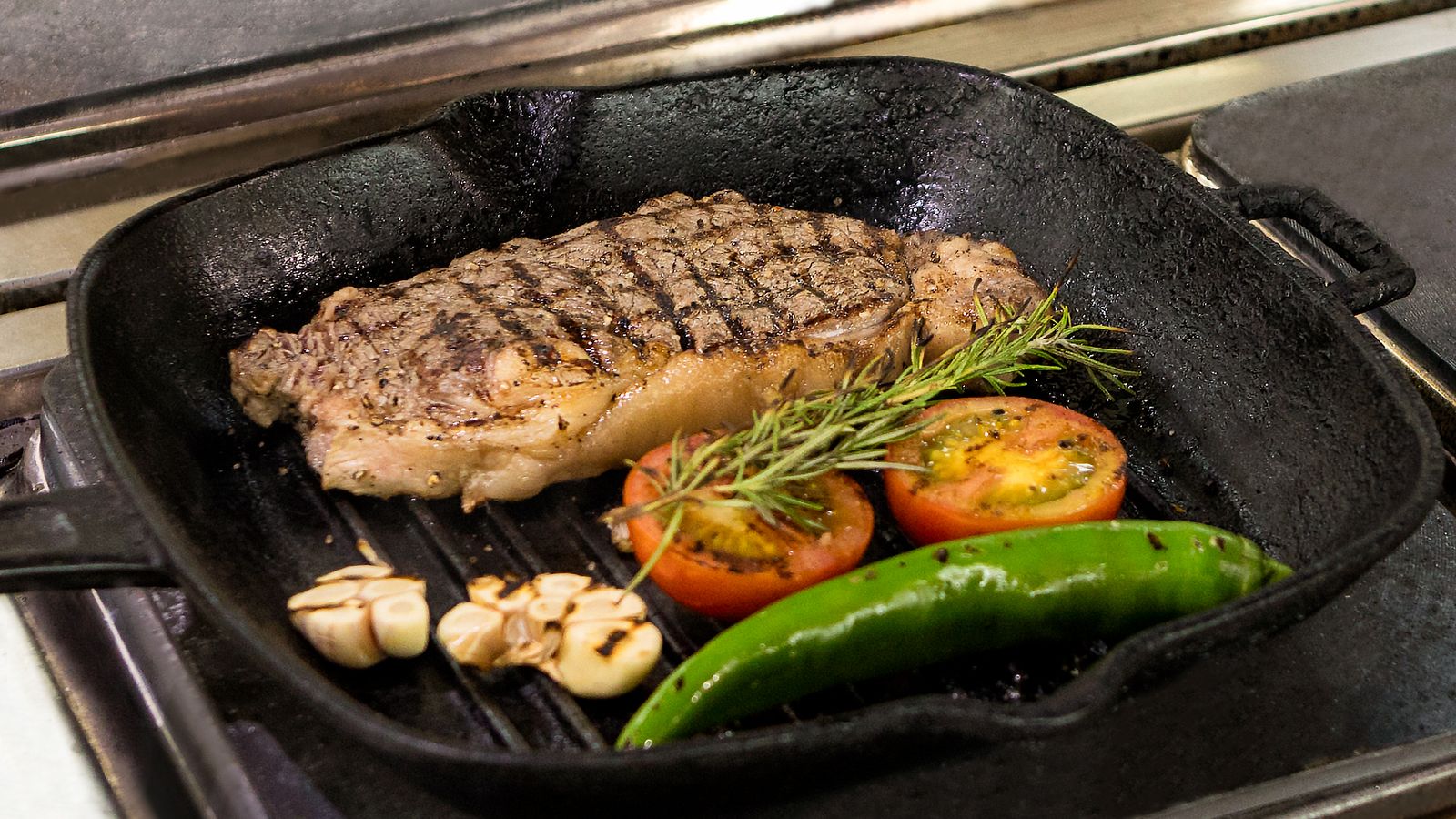 Cast iron style air fryer grill plate with sear marks cooling on a countertop before storage