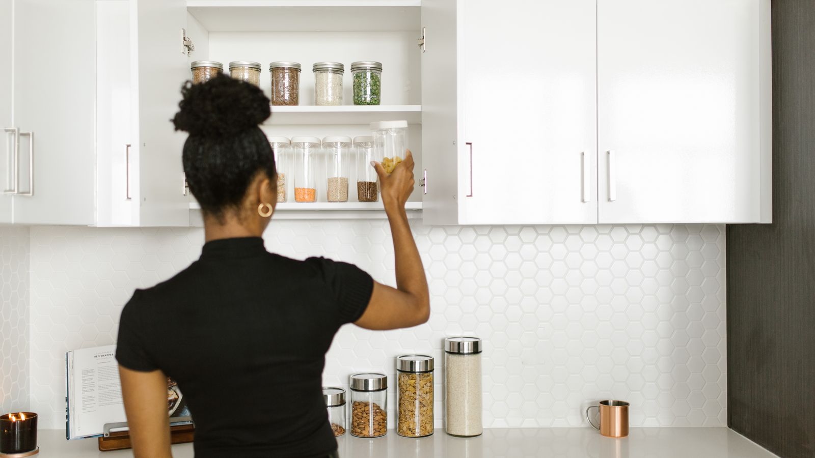 Clean glass jars and containers arranged neatly inside a kitchen cabinet