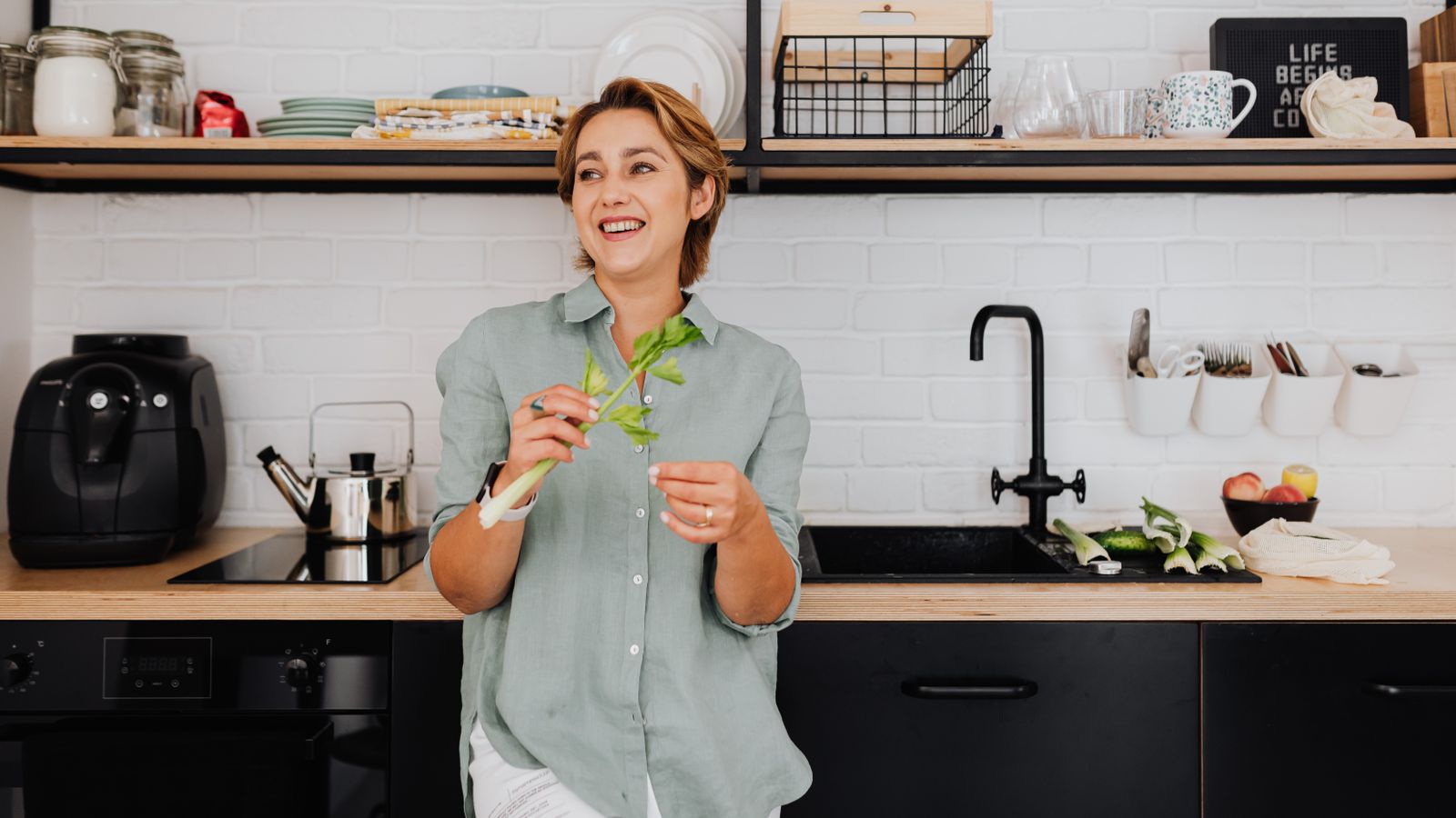 Compact air fryer stored on an open kitchen shelf near other small appliances