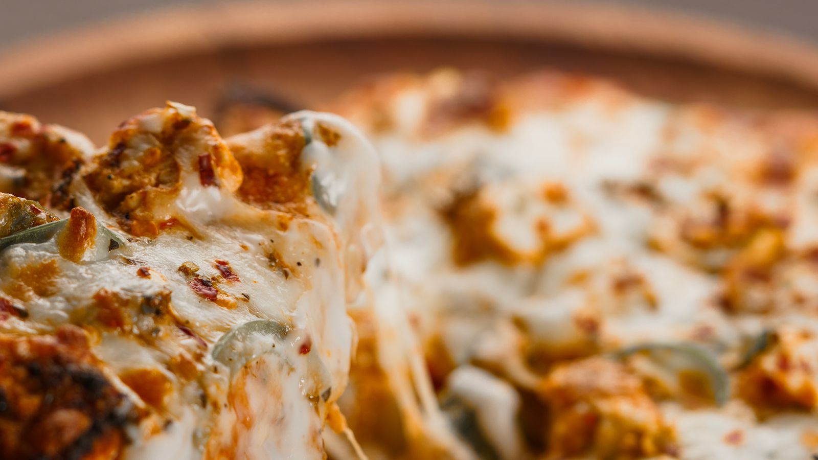 Close-up of melted cheese bubbling on a slice of pizza fresh from the air fryer