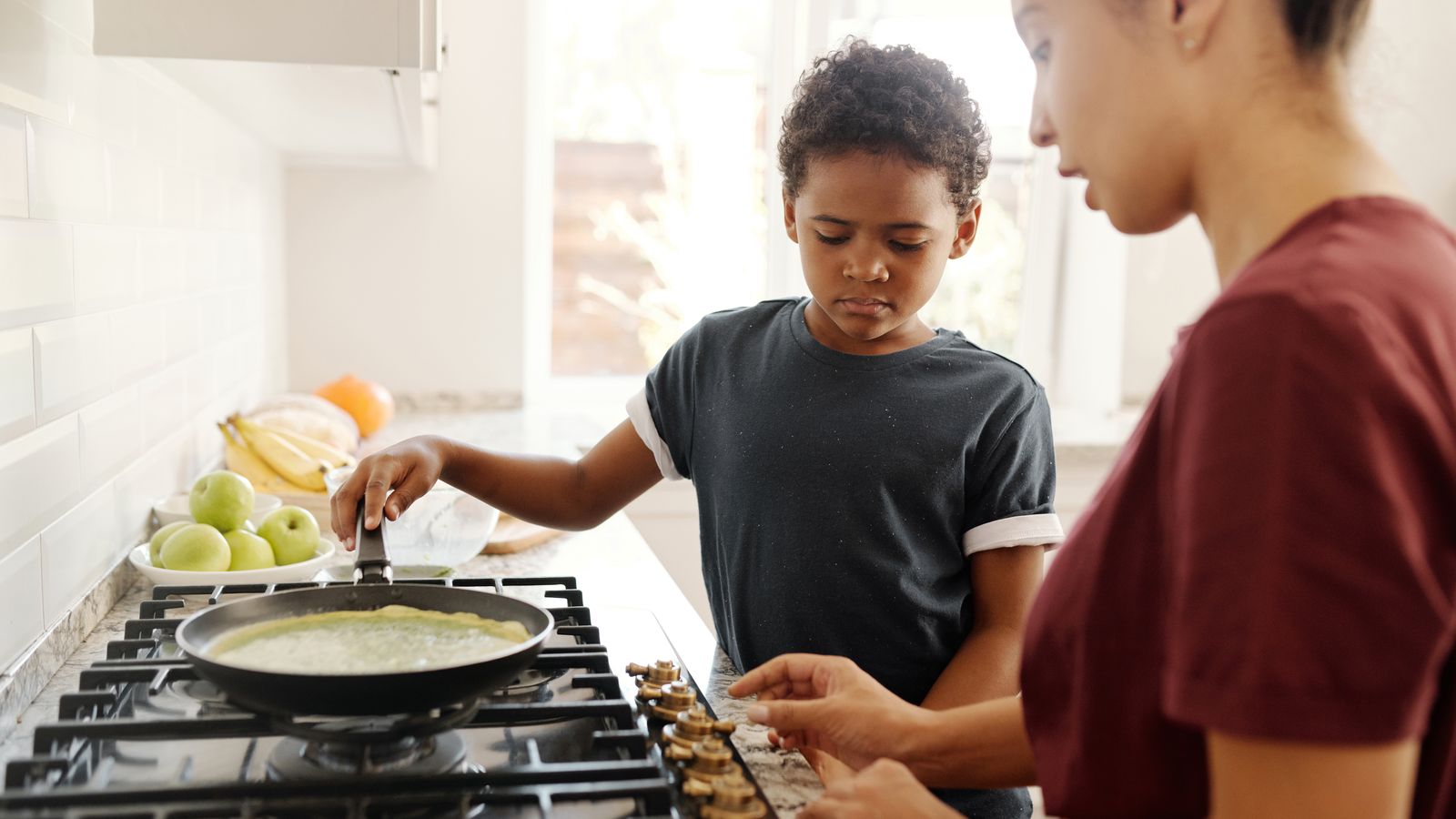 Parent preparing a quick weeknight meal in a busy household kitchen
