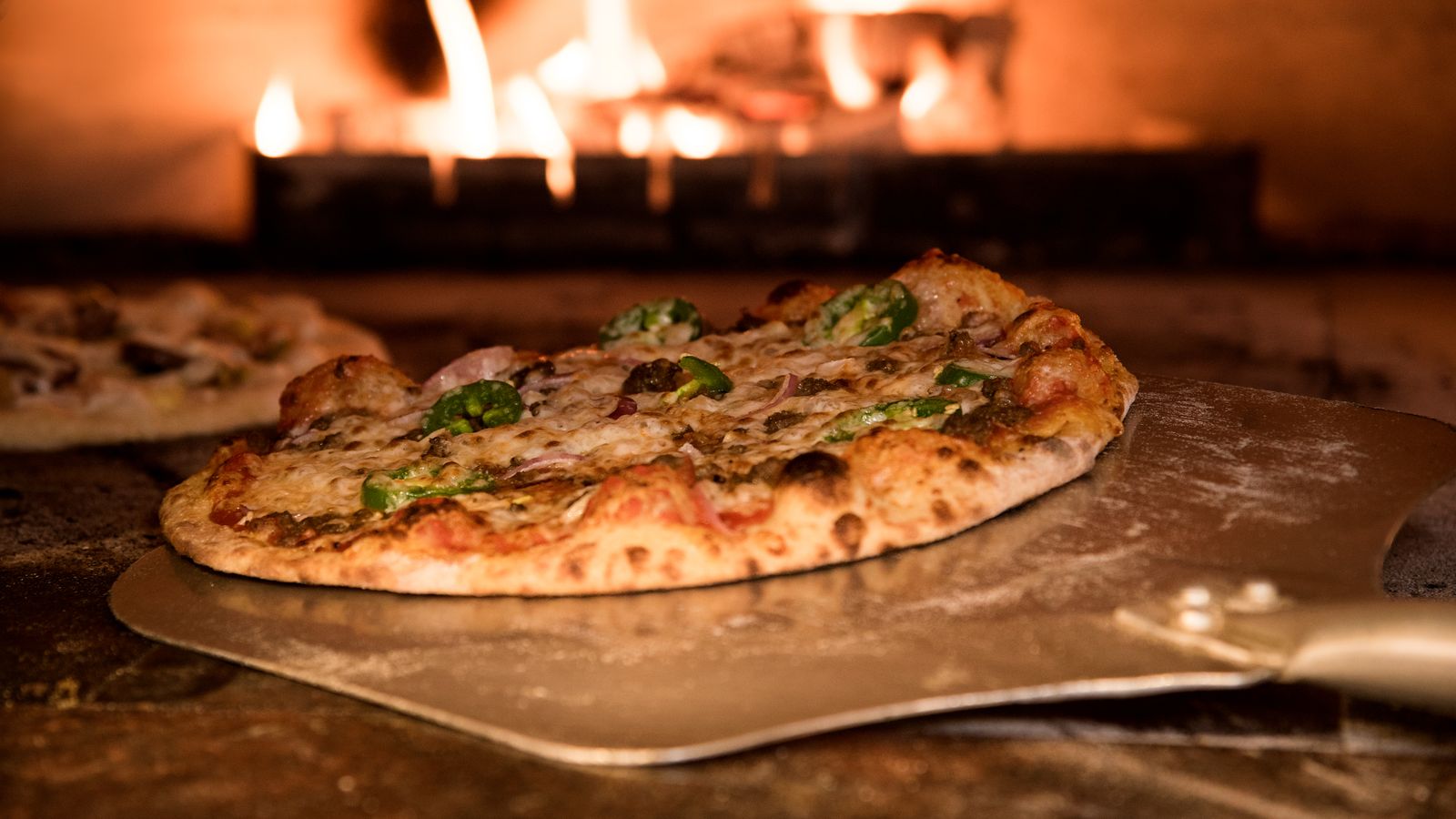 Fresh pizza baking on a hot steel slab inside a home oven